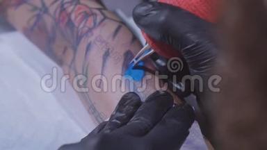 专业纹身师在一个年轻女孩的手上做纹身`纹身师在工作室做纹身，特写